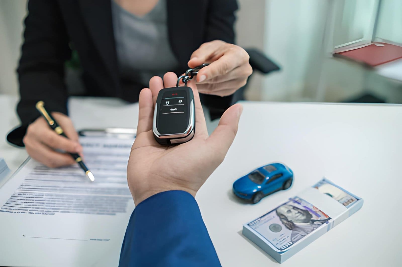 Customer receiving car key fob with cash and contract during buy here pay here in Venice FL