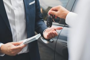 Venice cash for cars—customer handing over keys during vehicle transaction with dealer.