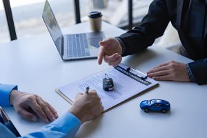 Buy here pay here Sarasota no credit check professional reviewing documents outside modern residential property