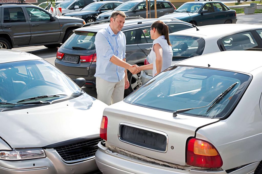 Bradenton FL auto dealers customers shaking hands near damaged cars in parking lot after minor collision