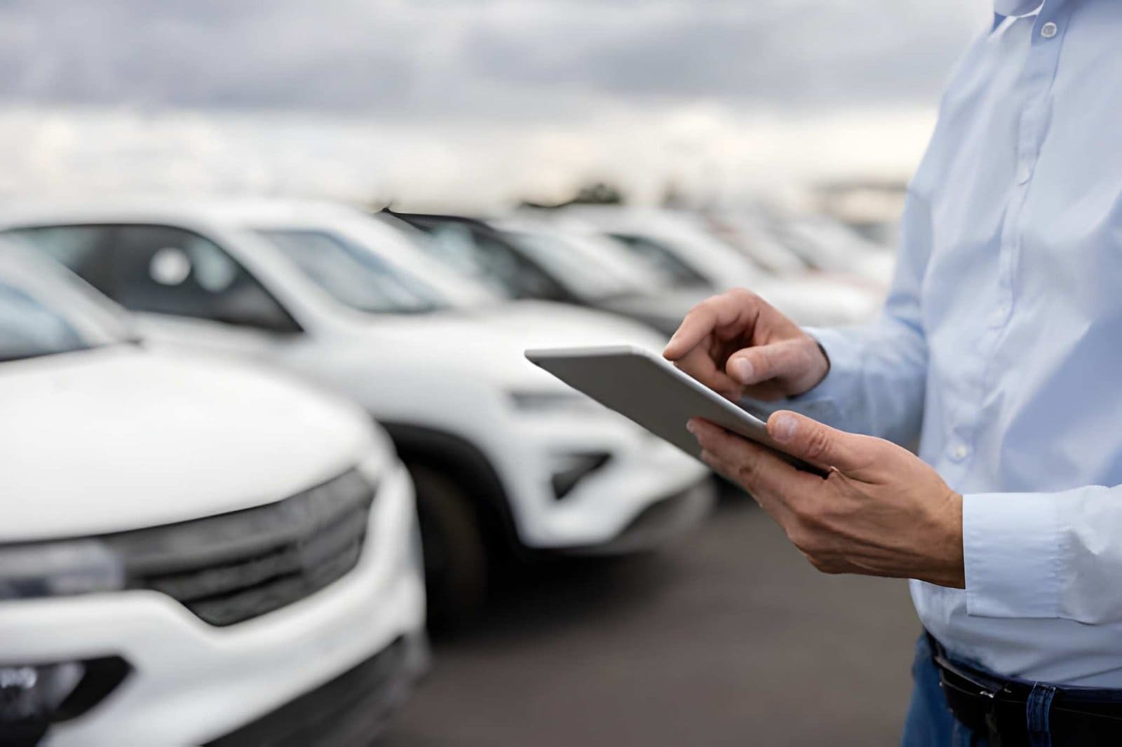 Car dealers in Venice FL using tablet technology to manage vehicles in dealership lot.
